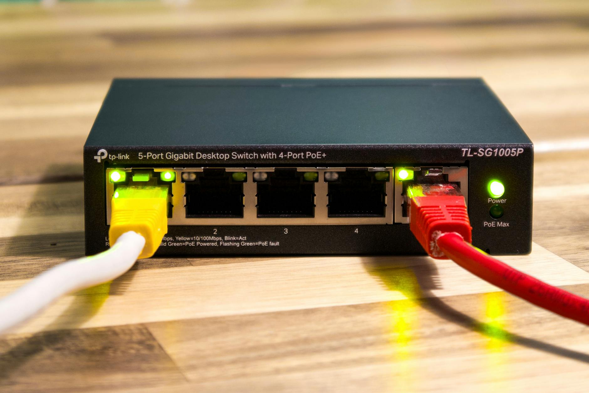 Przełącznik Ethernet TP-Link z podłączonymi żółtymi, czerwonymi i białymi kablam