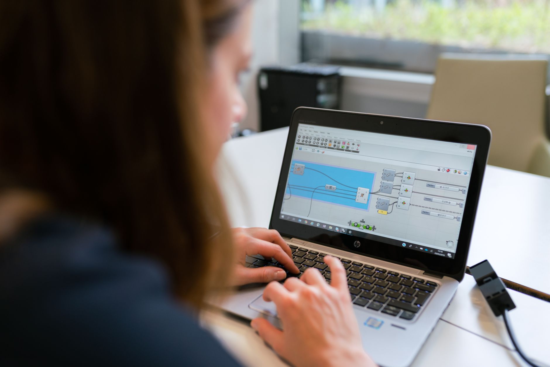 Inżynierka analizuje oprogramowanie SAM na laptopie w biurze