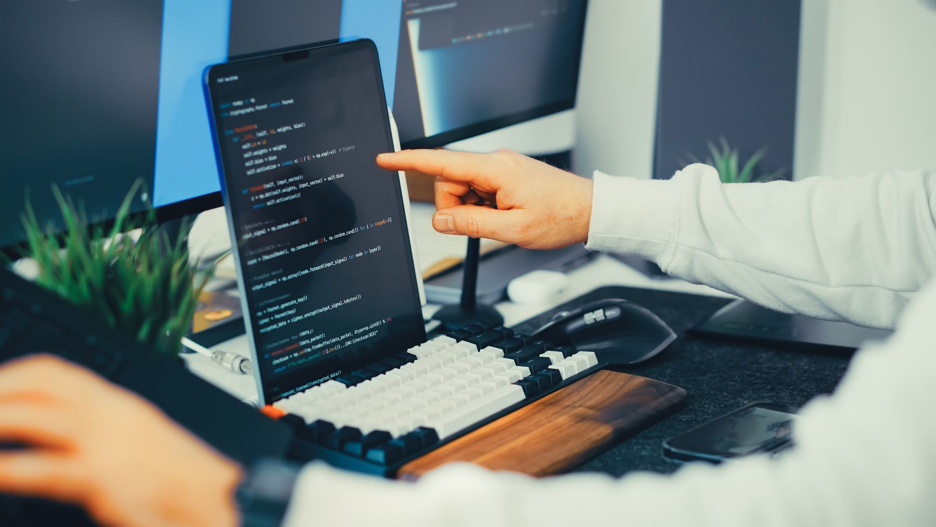Programista pracujący nad kodem na laptopie i monitorze w biurze